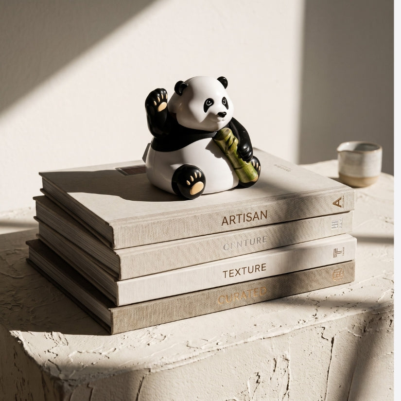 Panda figurine on a stack of books with a soft light background. solar panda, waving panda figurine, solar powered toy, desk decor, panda gift, eco-friendly gift, Asian novelty decor, solar waving figure